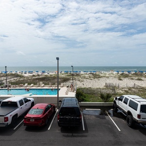 Enjoy a stunning beachfront view from this inviting space, complete with a pool and comfortable seating for relaxation