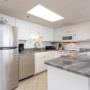 Bright kitchen features white cabinetry, granite countertops, and a convenient breakfast bar for casual dining