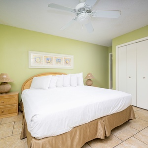 Guest bedroom featuring a large king bed, soft linens, and calming green walls for a relaxing getaway