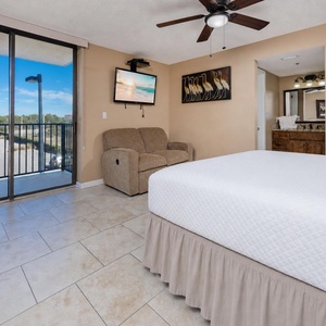 This king master suite welcomes you to unwind with coastal art and a cozy loveseat beside your balcony door