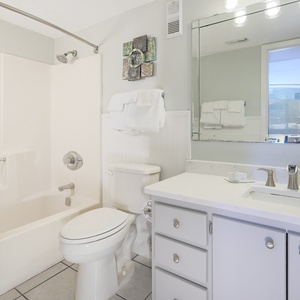 Guest bathroom featuring a clean design with a spacious vanity, a relaxing tub, and fresh towels for your comfort