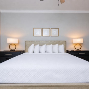 Experience restful nights in this guest bedroom featuring a king bed, soft linens, and stylish bedside lighting
