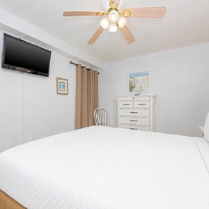 Rest in comfort on plush queen bedding while enjoying shows on the TV in this serene guest room