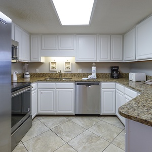 Modern kitchen featuring white cabinetry, granite countertops, and stainless appliances, perfect for meal preparation