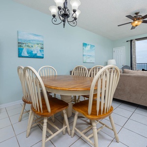 Gather around the wooden dining table, enjoying the inviting decor and views from the large windows
