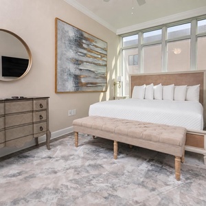 Experience serene comfort on king bedding, streaming your favorite shows as sunlight fills this guest bedroom
