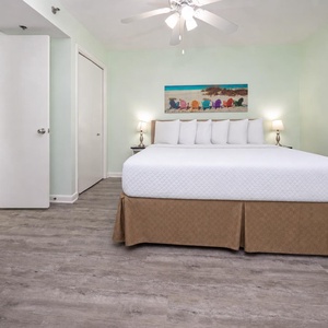 Unwind in this serene king suite, featuring a cozy bed, soft lighting, and beach decor for a relaxing stay