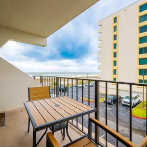 Enjoy a relaxing moment on the balcony with a view of the beach, perfect for unwinding after a day of adventure