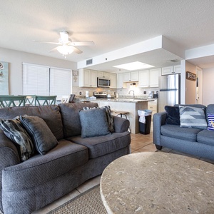 The living area features a cozy couch with queen sleeper, a stylish coffee table, and a dining space for relaxing gatherings