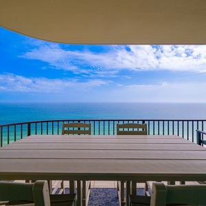 Gather around the spacious table on your balcony, enjoying the tranquil coastal views and creating lasting family memories