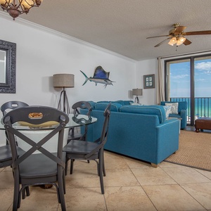 Unwind in the inviting living area with plush seating, a dining table, and stunning views of the turquoise waters