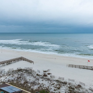 Experience serene coastal views from your balcony, with soft waves lapping against the sandy shore below