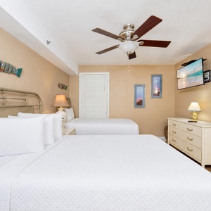 A queen and a twin bed dressed in clean linens invite you to unwind while streaming shows on the wall TV