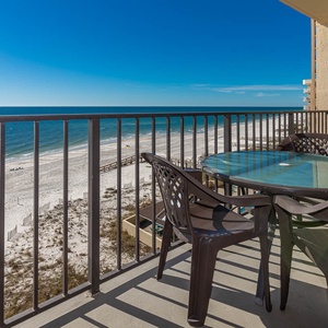 Relax on the balcony with a glass table and chairs, enjoying breathtaking views of the serene beach and turquoise waters