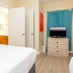 Relax in the comfortable guest room featuring queen beds, a TV, and cheerful decor that enhances your stay