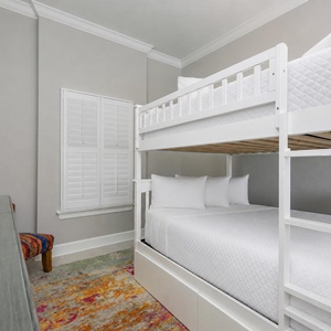 Climb the ladder to the top twin bunk, or settle onto the roomy lower double bed with fluffy pillows in this guest room