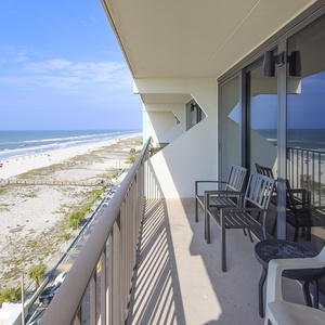 Enjoy a relaxing moment on the balcony with stunning beach views and comfortable seating for your getaway
