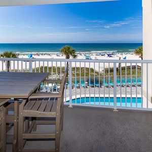 This balcony offers a stunning view with a wooden table and chairs, perfect for relaxing and enjoying the scenery