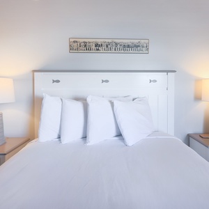 This inviting bedroom features a comfortable bed with plush pillows, soft lighting, and a nearby bathroom for convenience