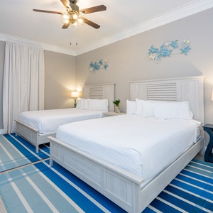 Fun guest bedroom with two queens, blue accents, and playful turtle decor