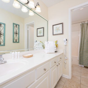 Refresh in this master bathroom featuring a spacious vanity, decorative accents, and a relaxing tub-shower