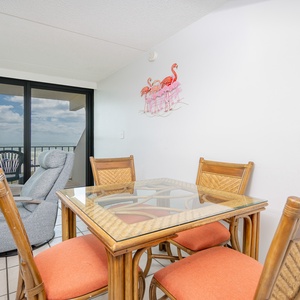 Dining space featuring a glass table, cozy seating for four, and a scenic view from the balcony