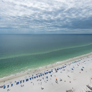 Gaze out from your balcony at the beachgoers creating joyful memories along the inviting shoreline below