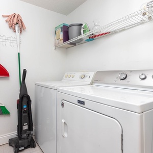 Keep your clothes fresh with the convenient laundry area featuring a washer, dryer, and essential cleaning supplies