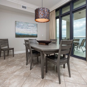 This dining area features a stylish table and chairs, with a beautiful view of the beach through large windows