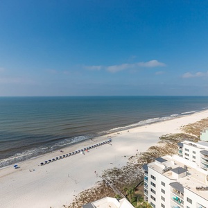 Stroll the wide beach, feel the gulf breeze, and take in umbrellas dotting the shoreline toward the horizon