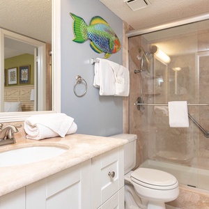 Stylish bathroom featuring a vanity, modern fixtures, walk-in shower, and vibrant coastal decor