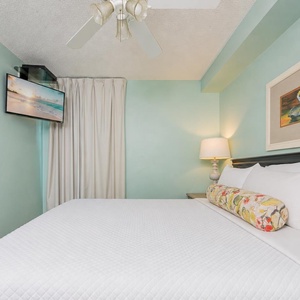 Fluffy pillows invite you to relax in the king suite for a calm movie night after a fun day at the beach