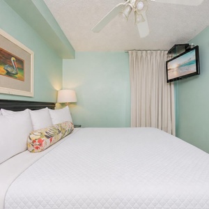 Fluffy pillows invite you to relax in the king suite for a calm movie night after a fun day at the beach