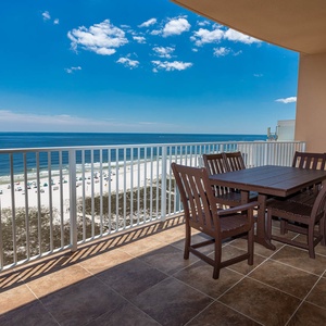 Breathe in the fresh coastal air as you unwind at the spacious balcony table, soaking in stunning beach views