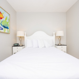 Experience restful nights in this inviting guest bedroom, featuring a comfortable queen bed and colorful fish artwork