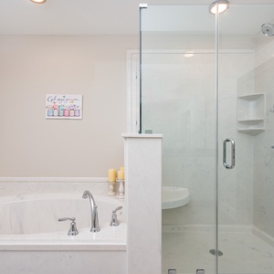 Indulge in relaxation with a soaking tub and walk-in shower, complemented by soft lighting and decorative accents