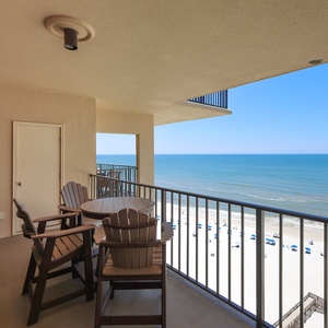 Enjoy breathtaking views from the balcony, featuring comfortable seating and a serene beachfront atmosphere