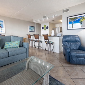 This inviting living area features a comfortable sofa, stylish decor, and a view of the beach, perfect for relaxation