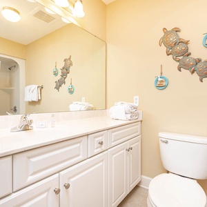 Refresh after beach adventures in this guest bath, surrounded by cheerful decor that invites relaxation