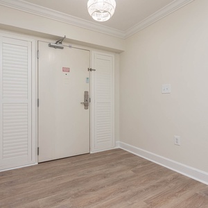 This welcoming entryway features light wood flooring and a stylish chandelier, setting a bright tone for your stay