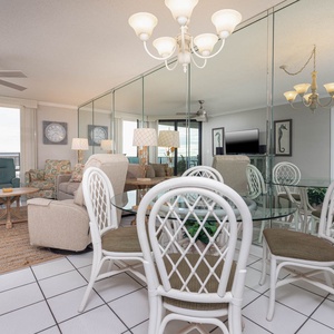 Enjoy meals around the glass dining table with views of the inviting living area and the balcony beyond