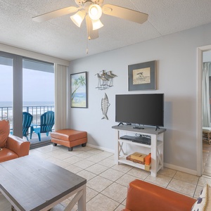 This inviting living area features comfortable seating and a stunning beachfront view from the large sliding glass doors