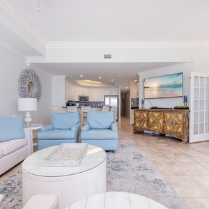 Inviting living area features cozy blue chairs, queen sofa-sleeper, a stylish coffee table, and a large TV for entertainment