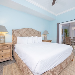 Relax in this inviting master suite featuring a plush king bed and a serene view through sliding glass doors