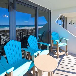 Relax on the balcony's bright blue chairs, enjoying stunning beach views and a perfect spot for morning coffee