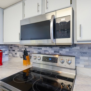 Modern kitchen features sleek cabinetry, marbled countertop, Keurig, and coffee maker, perfect for preparing meals and drinks