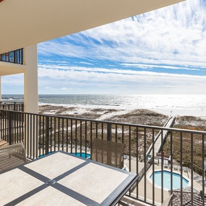 Balcony seating offers a serene view of the beach and pool area, inviting relaxation in a tranquil coastal setting