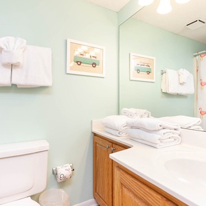 Refresh in the cheerful guest bathroom featuring soft towels, a spacious vanity, and playful decor