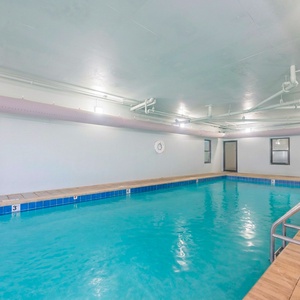 Swim in the indoor pool with a view of palm trees and beach access, perfect for relaxation and fun during your stay