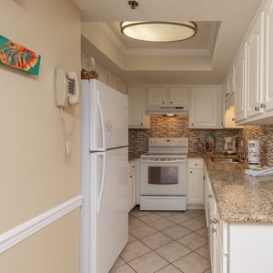 This kitchen features white cabinetry and granite countertops, perfect for preparing meals